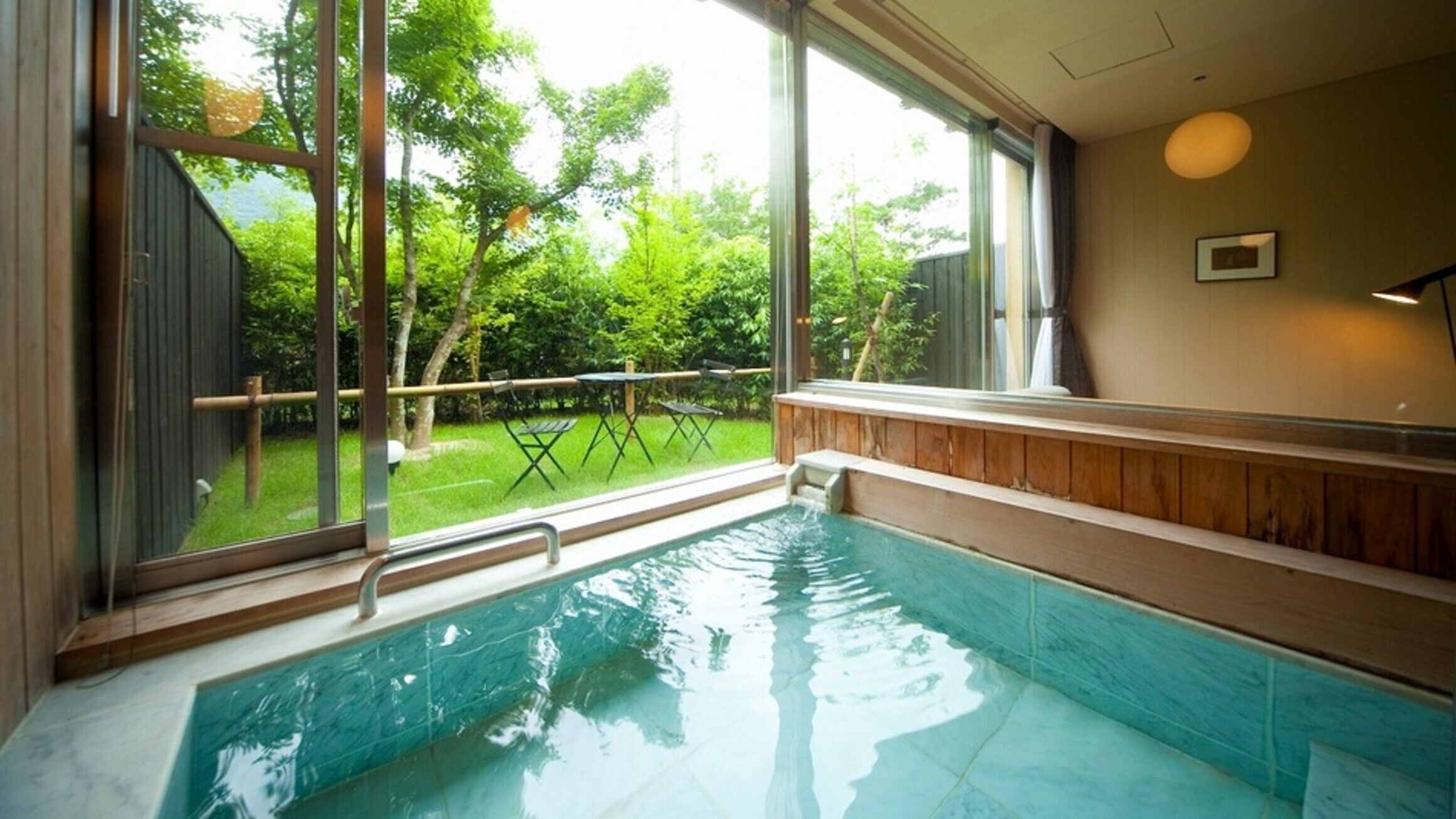 A hot tub with a view of a grassy yard and trees.