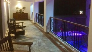 A corridor with a wooden bench, a small table, and a cabinet. The corridor has a railing on one side and a balcony with a railing on the other. - Quinta Alberto Boutique Hotel (San Blas)