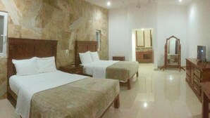A hotel room with two beds, a wooden dresser, a mirror, and a television. - Quinta Alberto Boutique Hotel (San Blas)