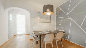 Et spiseområde med et bord, stole og en hængende lampe.