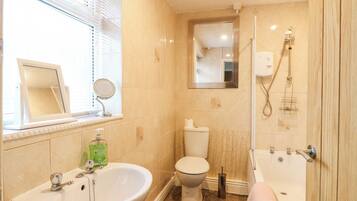 Een badkamer met een wastafel, toilet en bad.