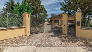Une entrée fermée par un portail, avec un chemin de pierre menant à un bâtiment.