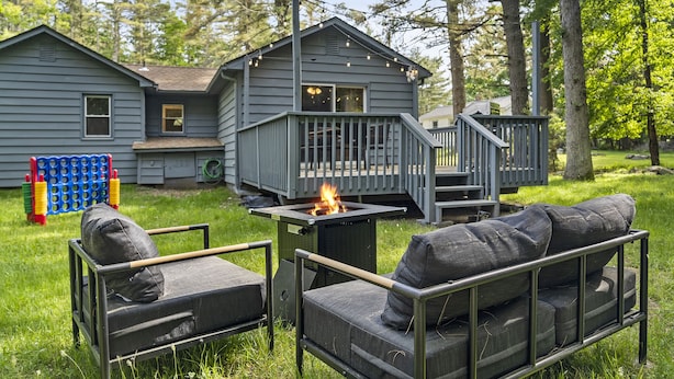 A backyard with a fire pit, outdoor furniture, and a deck. - Retro Countryside Cabin | Cozy Upstate NY Private Retreat! (Eldred)