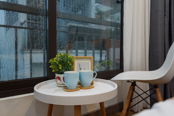 A small round table with two blue cups and a small potted plant.