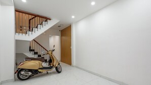 A modern interior with a scooter parked near a staircase.