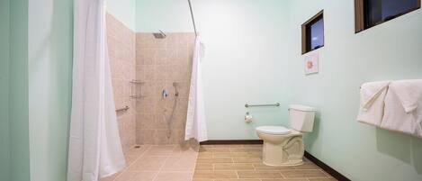 A bathroom with a shower, toilet, and towel rack.