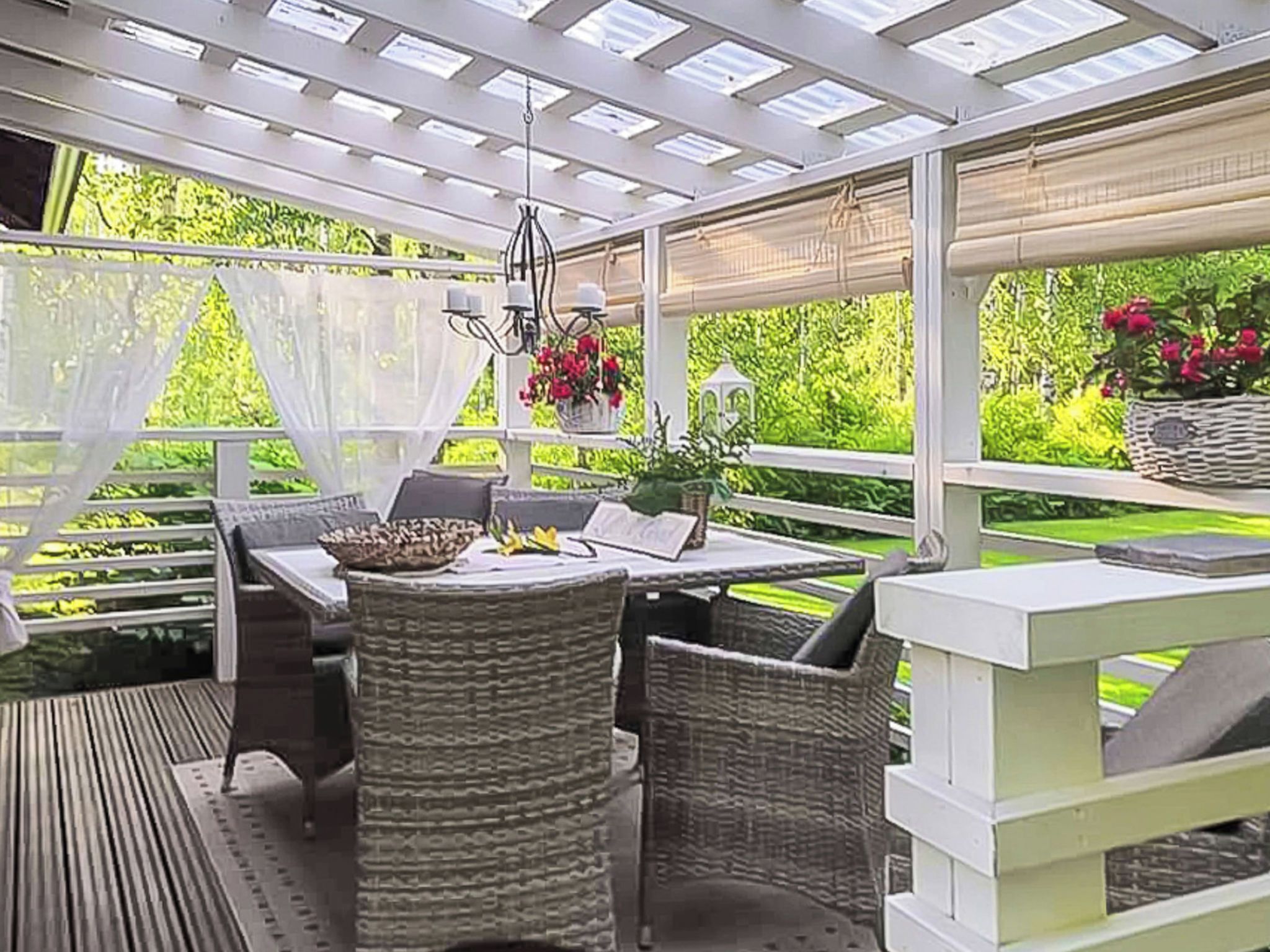 An outdoor patio with wicker furniture, a table, and a hanging light fixture.