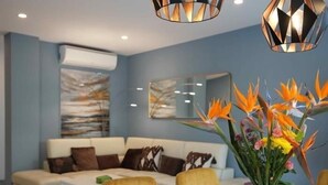 Ein modernes Wohnzimmer mit einer Couch, einem Couchtisch und einer Vase mit Blumen.