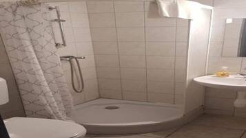 Een douche, handdoeken, zeep, toiletpapier