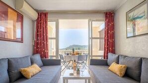 A modern living room with grey sofas, a small coffee table, and red curtains. - L'Esquinade P1 111 by Interhome (Agay Village Cap Esterel)