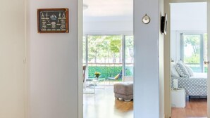 Un espacio habitable amplio con un gran ventanal, una mesa de comedor y una zona de estar acogedora con un sofá y un reposapiés.