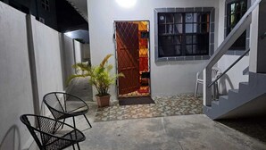 A courtyard with a staircase, a potted plant, and a metal chair. - Cozy, comfortable, and beautiful apartment located in a safe gated community. (Georgetown)