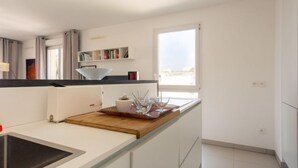 Una cocina moderna con estufa integrada, encimera de madera y ventana que proporciona luz natural.