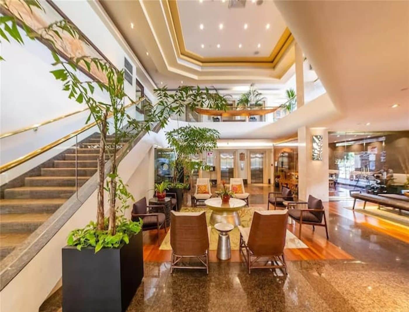Eine großzügige Lobby mit einer zentralen Sitzecke, einer Treppe und mehreren Ebenen.