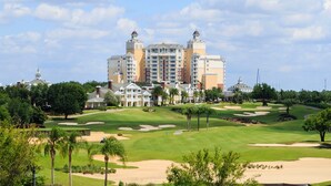 A large hotel with multiple towers and a well-maintained golf course in the foreground. - 3BR Reunion Townhome w/ Golf Views & Games (Kissimmee)