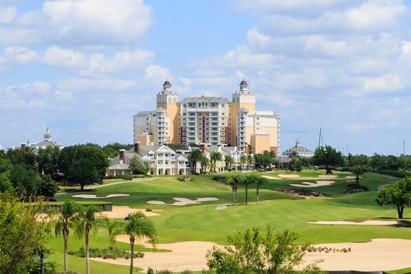 A large hotel with multiple towers and a well-maintained golf course in the foreground.