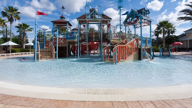 A water park with a central play structure, multiple slides, and a surrounding pool area. - 3BR Reunion Townhome w/ Golf Views & Games (Kissimmee)
