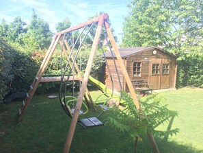 Relax in a serene garden setting, surrounded by lush greenery and a charming cabin.