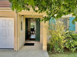 Enter a warm and inviting space, where a double door leads to a dining area with a table and chairs.