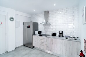 Een moderne keuken met een witte betegelde spatwand, roestvrijstalen apparatuur en een inbouwoven.