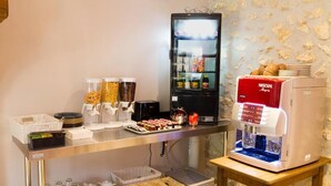A kitchenette with a Nescafe coffee machine, a refrigerator stocked with beverages, and various food items on the counter. - Hôtel Les Petits Oreillers (Saint-Martin-d'Ardèche)