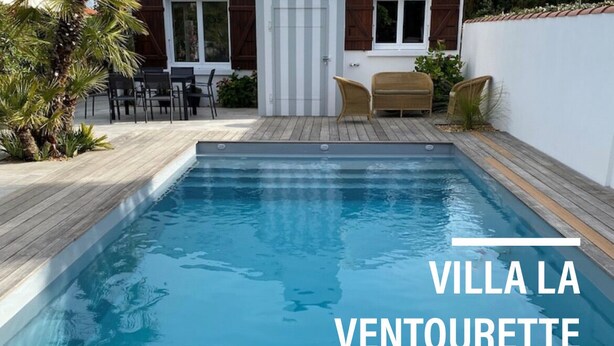 Eine Villa mit Swimmingpool, Gartenmöbeln und einem weißen Gebäude mit der Aufschrift 'La Ventourette'.