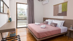Una habitación de hotel moderna con una cama grande, un escritorio y un balcón con vistas.
