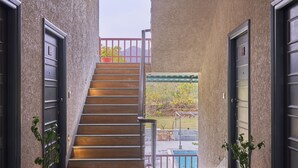 A hallway with a staircase leading to a balcony. - The Hunting Lodge (Udaipur)