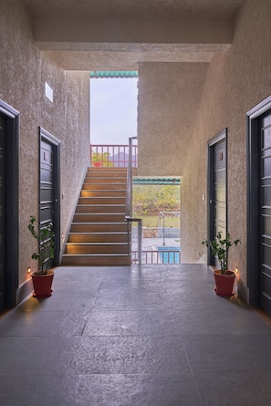 Step into a tranquil oasis, where a covered entrance welcomes you to a serene poolside retreat.