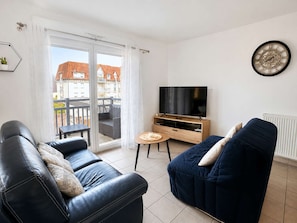 A modern living room with a sofa, a television, and a small table.