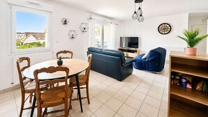 Un salon moderne avec une table à manger, un canapé et un téléviseur.