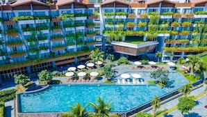 A modern hotel with multiple balconies, a central swimming pool, and outdoor seating areas. -  Bellerive Hoi An Resort and Spa. (Da Nang)