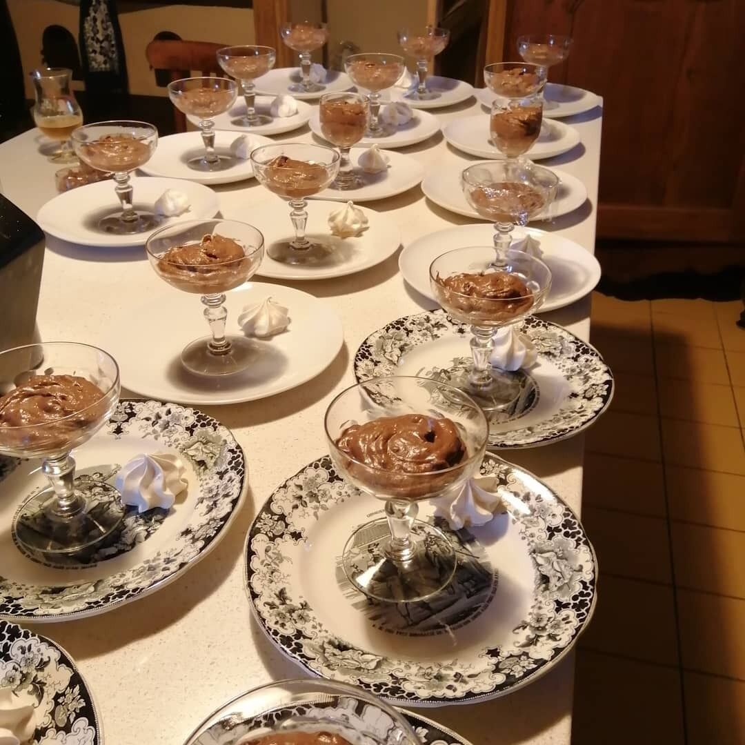 Una mesa servida con varios postres, cada uno con una copa y una cucharada de crema.