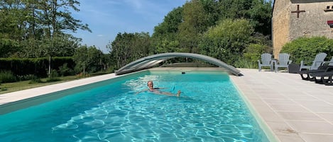 Een seizoensgebonden buitenzwembad, parasols voor strand/zwembad