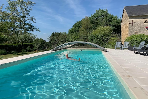 Una piscina al aire libre de temporada, sombrillas
