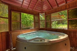 A hot tub with a wooden exterior and large windows.