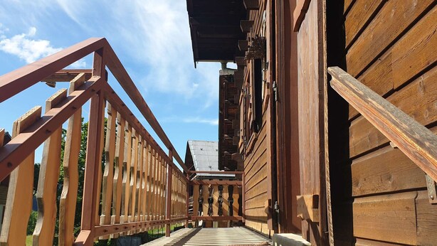 Una scala in legno conduce a un edificio con tetto in metallo.