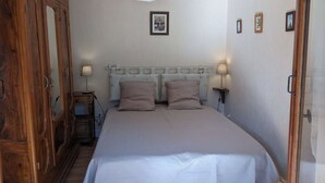 Una camera da letto con un letto grande, un armadio in legno e un lampadario.