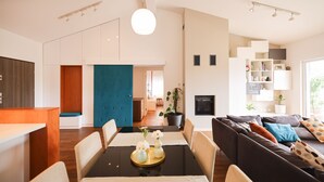 A modern living room with a dining area, a sofa set, and a TV.