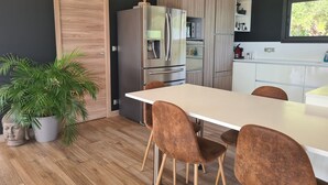 A modern kitchen with a large island, stainless steel appliances, and wooden cabinetry.