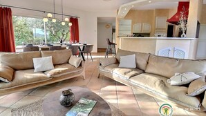 Een moderne woonkamer met twee banken, een salontafel en een eethoek met een tafel en stoelen.