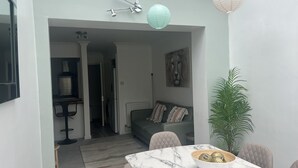 A modern living room with a marble table, a sofa with cushions, a potted plant, and a painting on the wall. - Forever Summer (Lymington)