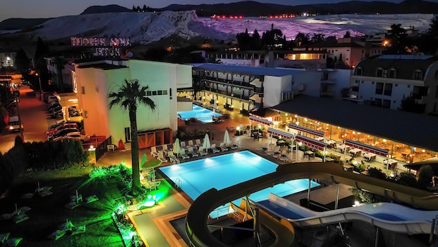 Un resort con una piscina grande, un tobogán de agua y un área de restaurante.