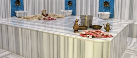 A marble bathroom with a large sink, two gold-colored basins, and a towel rack.