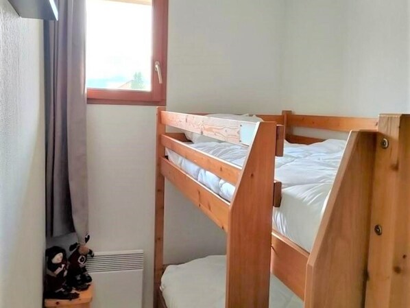 A small, single-room accommodation with a bunk bed and a window.