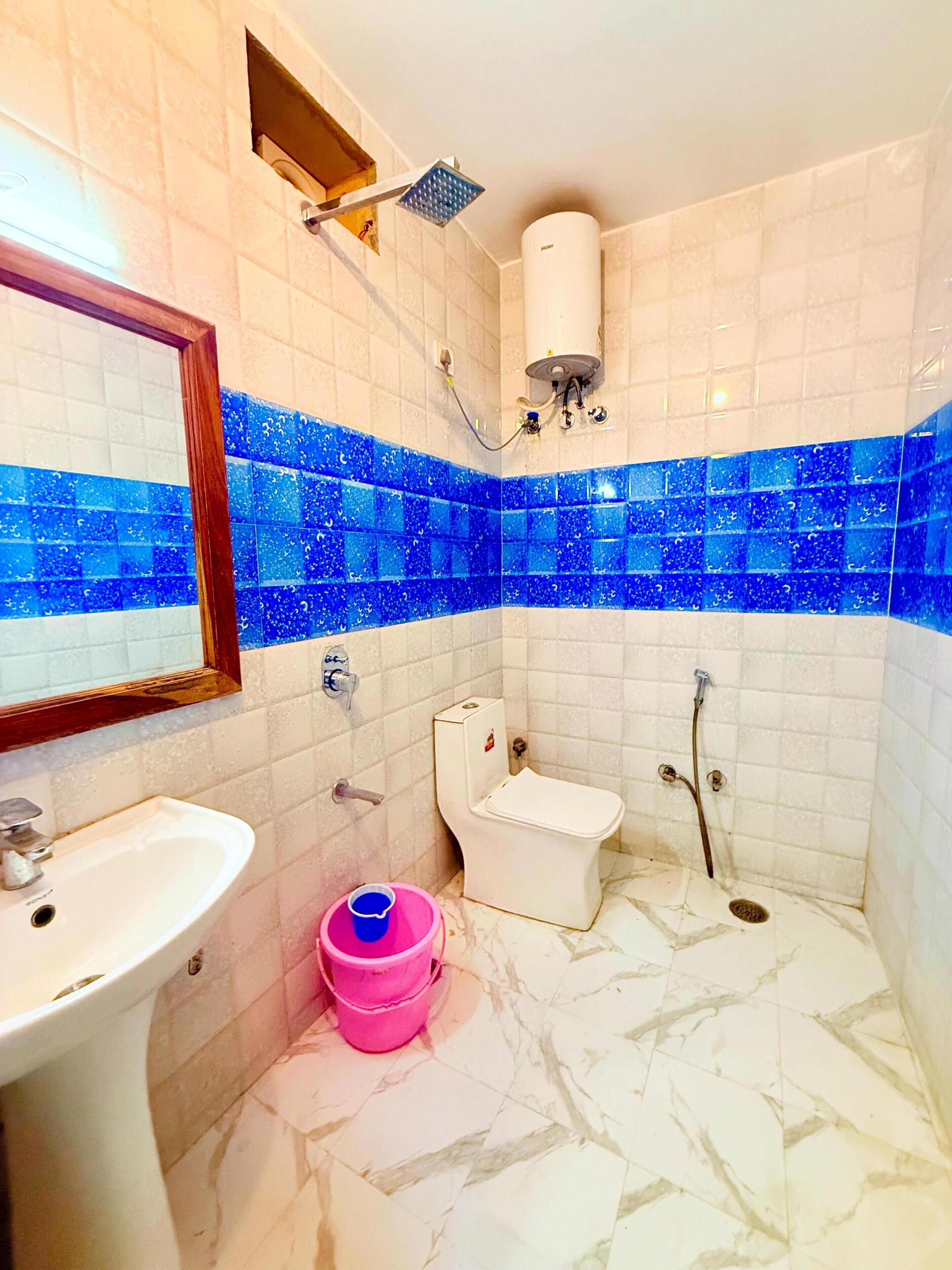 Een badkamer met een wit wastafel, toilet en douche.