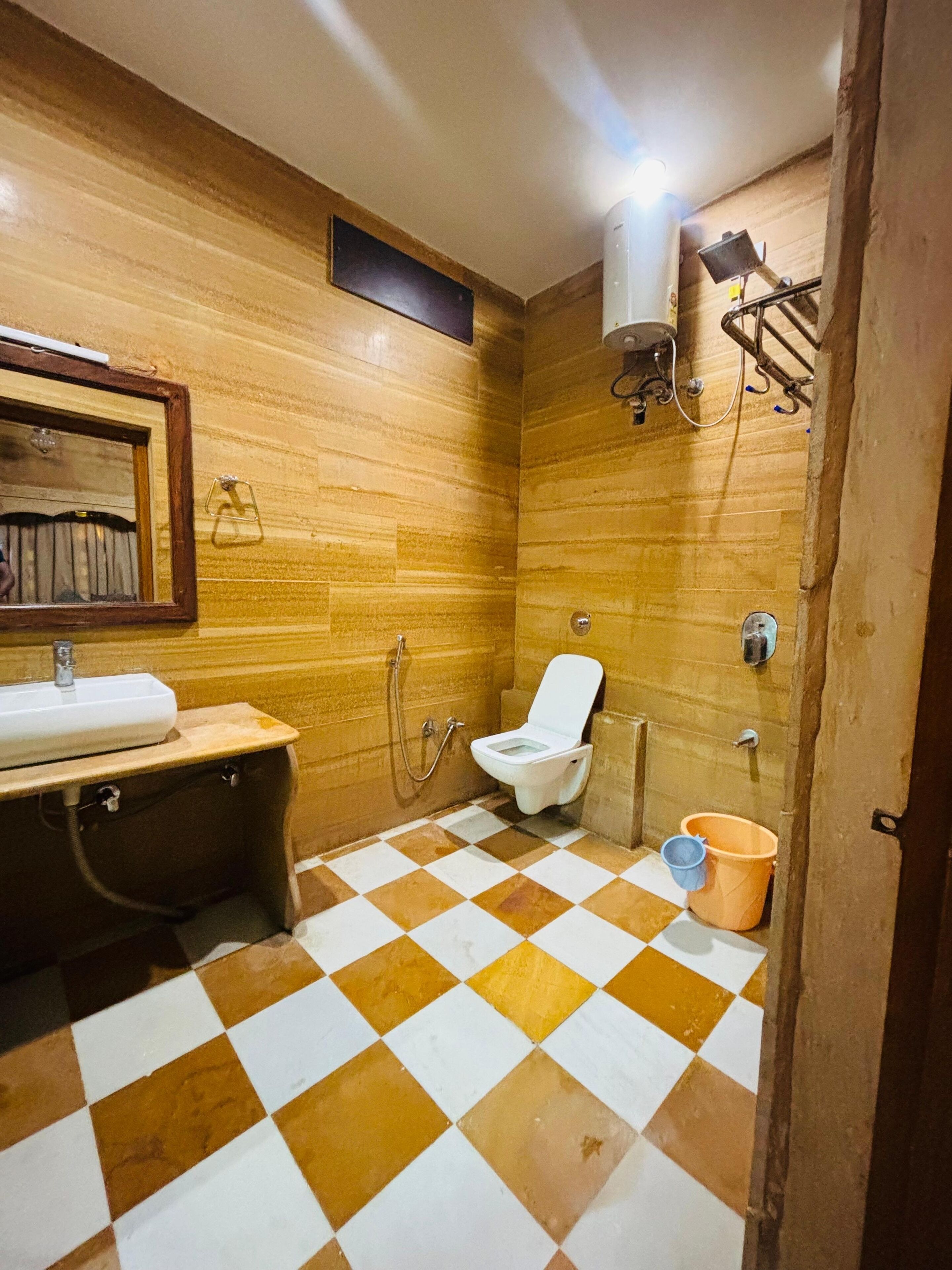 A bathroom with a checkered floor, a toilet, a sink, and a shower.