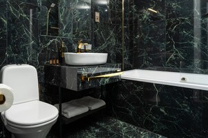 A modern bathroom with a white toilet, a white sink, and a bathtub.