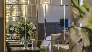 A luxurious interior with a mirrored wall, elegant chandeliers, and plush seating. - St.Palace hotel (Vilnius)