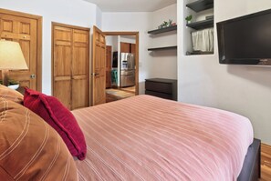 A bedroom with a bed, a desk, a chair, a television, and a wardrobe. - Walk to Lift. Hot Tubs. Elevator. Close to Lake. (Keystone)